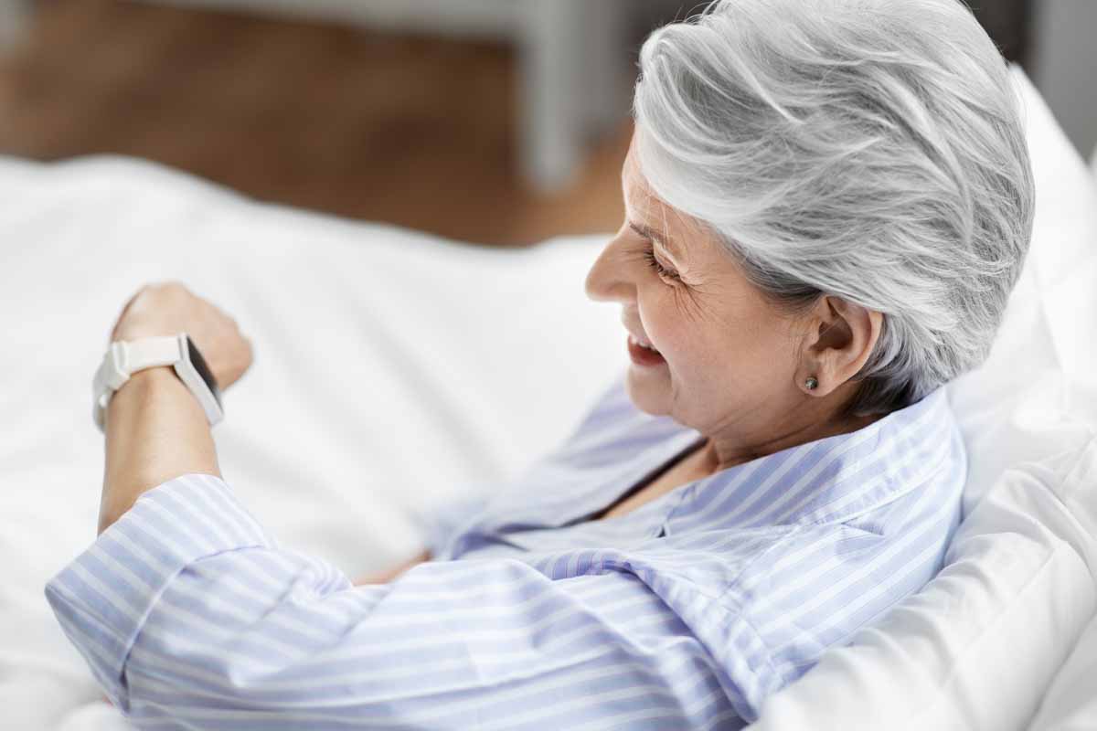 ederly person looking at a smartwatch when they first awake