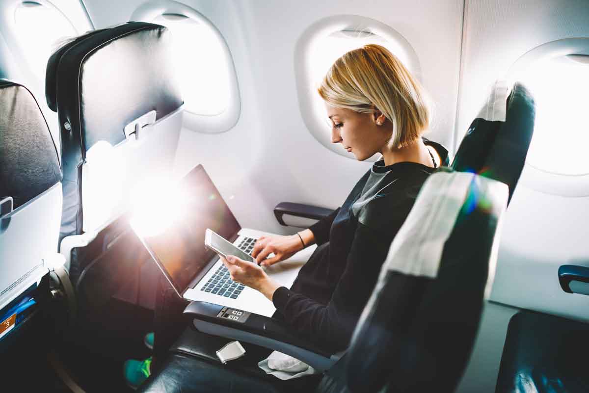image of a women on a phone, working on a computer and receiving a notification
